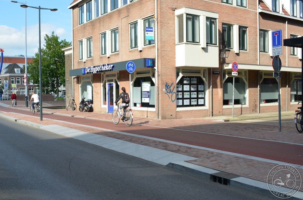 Image 3: A continuous footway across a side road, with wide sloping kerbstones provided for vehicles to enter / leave the main road to / from the side road (Source: Cycling Embassy of Great Britain https://www.cycling-embassy.org.uk/dictionary/continuous-footway)